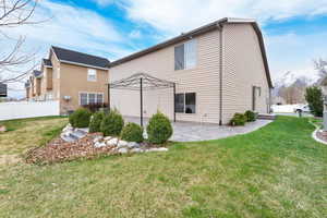 Back of house featuring a lawn, fence, and a patio area