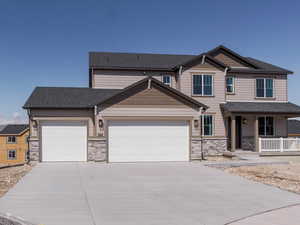 Craftsman-style home featuring fence, an attached garage, stone siding, driveway, and covered porch