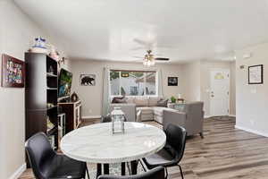 Dining space with baseboards, ceiling fan, and light wood-type flooring