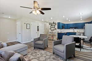 Living room featuring a ceiling fan, wood finished floors, baseboards, visible vents, and recessed lighting
