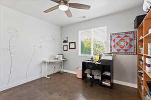 Office area featuring baseboards, visible vents, concrete flooring, and a ceiling fan