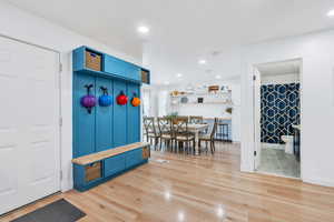 Garage entrance next to a hall tree for convenience storing, with recessed lighting, baseboards, visible vents, and light wood-type flooring