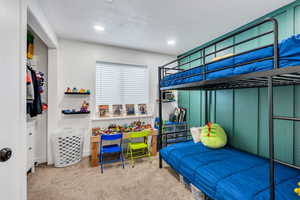 Bedroom in the basement featuring an accent wall, carpet flooring, a textured ceiling, and recessed lighting