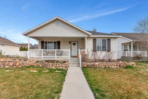 Bungalow featuring a porch and a front lawn