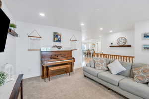 Living area featuring carpet, baseboards, and recessed lighting