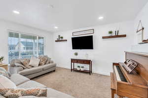 Living room featuring large window,carpet floors, and recessed lighting