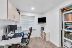 Office space in the basement, featuring light colored carpet, and closet.  Can be used as a bedroom.