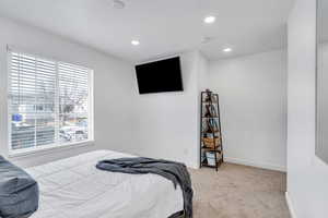 Bedroom with baseboards, recessed lighting, and light colored carpet