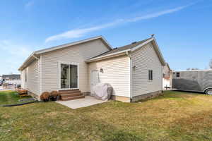 Back of property featuring a lawn and entry steps