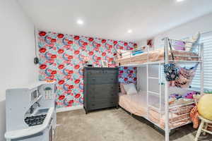 Carpeted bedroom in the basement with wallpapered walls, baseboards, and recessed lighting