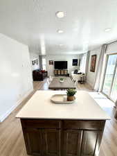 Interior space with plenty of natural light, baseboards, light wood-type flooring, and a textured ceiling