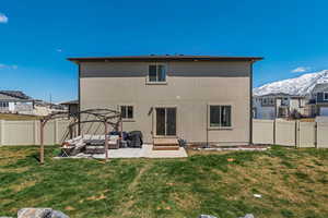 Back of house with outdoor lounge area, a fenced backyard, stucco siding, a lawn, and a gate