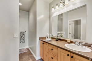Bathroom featuring baseboards, toilet, and vanity