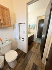 Bathroom with vanity, toilet, baseboards, visible vents, and LVP wood finished floors