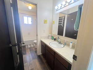 Bathroom featuring tub / shower combination, LVP wood finished floors, toilet, and vanity