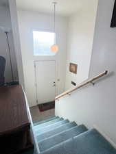 Stairs with carpet flooring and a textured wall