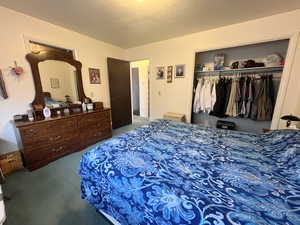 Bedroom with carpet, a closet, and a textured ceiling