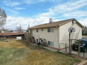 Back of house with a yard, a gate, fence.