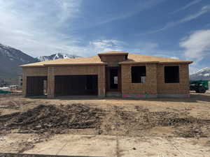 Property in mid-construction featuring an attached garage and a mountain view