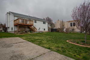 Back of property featuring a deck, stairway, and a yard