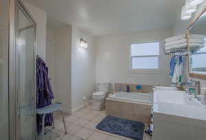 Full bathroom featuring a stall shower, tile patterned floors, toilet, a bath, and visible vents