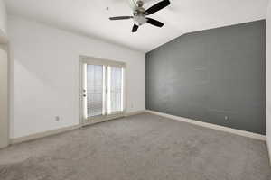 Empty room with baseboards, carpet floors, vaulted ceiling, and ceiling fan
