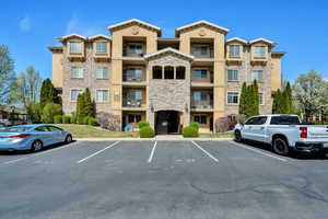 View of building exterior featuring uncovered parking