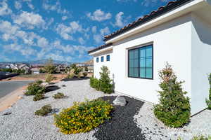 View of side of property with stucco siding, a mountain view, a tiled roof, and a residential view