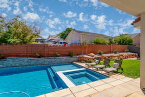 View of pool featuring an in-ground hot tub, patio surround, and a fenced backyard