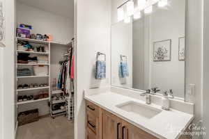 Bathroom with vanity and a spacious closet