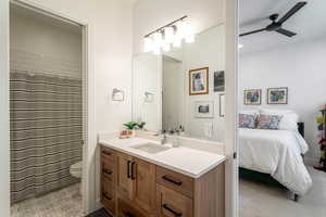 Ensuite bathroom featuring vanity, a ceiling fan, and a shower with curtain
