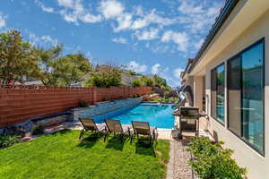 View of swimming pool featuring a fenced backyard, patio surround, and a water slide