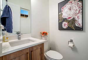 Half bathroom with vanity and toilet