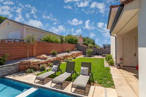 View of swimming pool featuring patio surround and a fenced backyard