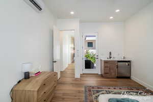 Bar with recessed lighting, wet bar, a sink, light wood-style floors, and dishwasher