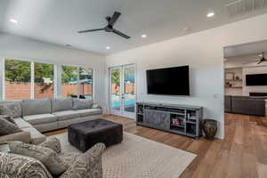 Living area with a ceiling fan, light wood-type flooring, recessed lighting, french doors, and a fireplace