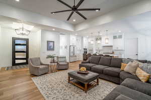 Living area featuring ceiling fan, light wood finished floors, and hanging lights