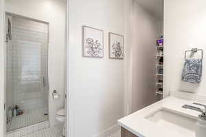Full bath featuring vanity, a shower stall, and light tile patterned flooring