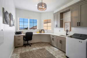 Office space with washer / dryer, built in desk, and a chandelier