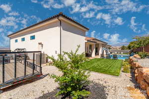 Rear view of house with a fenced backyard, a tiled roof, stucco siding, and a patio area
