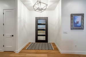 Entrance foyer with a chandelier and wood finished floors