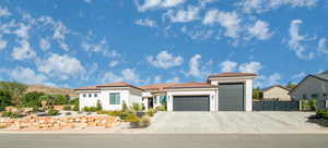 Mediterranean / spanish-style home with a garage, a tile roof, stucco siding, and concrete driveway