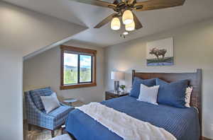Carpeted bedroom with a ceiling fan