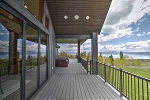 Deck with a water view and a yard