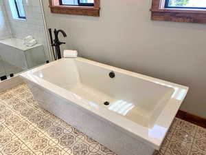 Full bath with a stall shower, tile patterned flooring, and a bath