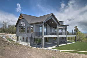 Back of house with a wooden deck, stairway, a lawn, a shingled roof, and a patio area