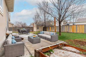 View of patio / terrace with outdoor dining space, a shed, a fenced backyard, an outdoor living space, and an outdoor structure