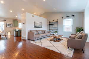 Living room featuring wood finished floors, recessed lighting, baseboards, and lofted ceiling