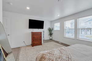 Primary Bedroom with multiple windows, carpet floors, and baseboards