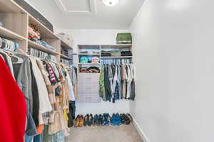 Walk in closet with carpet floors and attic access